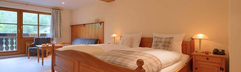 De sfeervolle en ruime familiekamer van hotel Hofgut Sternen, ingericht met veel hout voor een authentieke sfeer.