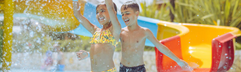 Kinderen hebben waterpret in het zwembad van camping Bella Italia.
