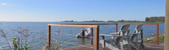 Houten vlonder met comfortabele stoelen en een prachtig uitzicht over het Markermeer op vakantiepark EuroParcs Markermeer.