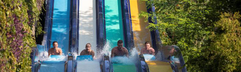 Kinderen en volwassenen racen tegen elkaar op de brede multislide waterglijbaan in het aquapark van Ali Bey Club in Side.