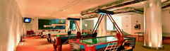 De gameroom van Hotel Eugenia Victoria met diverse speelautomaten en airhockeytafels.