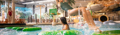 Kinderen die spelen op de leuke waterhindernisbaan in het Aquadome waterpark van Lalandia Billund in Denemarken.