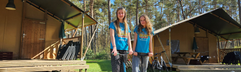 Twee meiden met een step voor de safaritenten op Landal Coldenhove, midden in de bossen van de Veluwe.