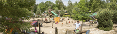 Overzicht van het binnenzwembad op Landal Heideheuvel waar gezinnen met kinderen zwemmen en spelen in het water.