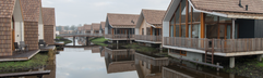 Overzicht van de moderne, duurzame waterwoningen die direct aan de waterwegen van vakantiepark Landal Reeuwijkse Plassen liggen.