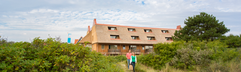 Het appartementengebouw van Landal Vlieduyn, prachtig gelegen midden in het groene duinlandschap van Vlieland.