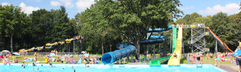 Overzicht van de buitenzwembaden bij Waterspeelpark Splesj met diverse spectaculaire waterglijbanen en volop zwemmende mensen.