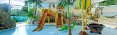 Het gethematiseerde kinder- en peuterbad in het zwemparadijs van Rhön Park Hotel, met palmbomen, kleine glijbanen en waterspeeltjes.