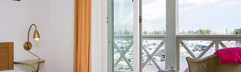 Slaapkamer in een appartement op Cape Helius met openslaande deuren naar het balkon en uitzicht op de jachthaven.