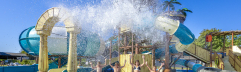 Een enorme emmer water kiept om over spelende kinderen in het waterpark