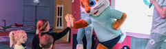 Kinderen geven parkmascotte Koos Konijn een high five tijdens een levendige meeleeftheatershow op het podium van Vakantiepark Egmond aan Zee.