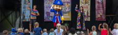Het animatieteam geeft een show op het podium met mascottes voor de kinderen