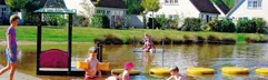Kinderen bouwen zandkastelen op het strandje aan de recreatieplas van Vakantiepark Hellendoorn.