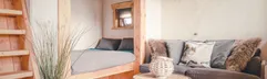 De gezellige woonkamer en bedstee in een boomhut op Vakantiepark Molke, ingericht met natuurlijke materialen en uitzicht naar buiten.