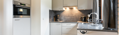 Interieur van een vakantiehuis op Reevallis met een moderne, compleet ingerichte witte keuken.