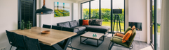 Overzicht van de ruime, modern ingerichte woonkamer met grote ramen die uitkijken op het landschap van Goeree-Overflakkee bij Vakantiepark Zeedijk.
