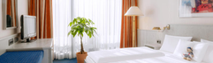 Een comfortabel opgemaakt bed in een van de hotelkamers van Dorint Hotel & Sportresort Arnsberg-Sauerland.