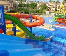 Een brede blauwe familieglijbaan met meerdere banen in het waterpark van Albir Garden Resort, waar je naast elkaar vanaf kunt glijden.
