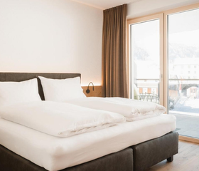 Moderne slaapkamer met tweepersoonsbed en balkon