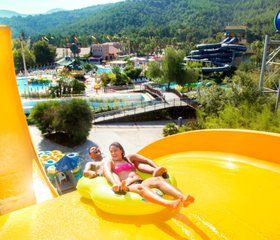 Kinderen glijden samen van brede familieglijbaan in Aqua Fantasy Kusadasi