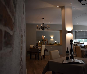 Chique restaurant in Hotel Atlanta met een rustieke bakstenen muur en een moderne inrichting in neutrale tinten