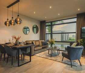 Modern en sfeervol interieur van een luxe vakantiewoning op Vakantiepark Bad Nederrijn, met een ruime woonkamer en eethoek.