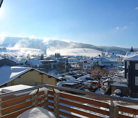 Het weidse winterse uitzicht vanaf een balkon van het Best Western hotel over het besneeuwde dorp Willingen en de omliggende bergen.
