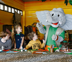 Kinderen knutselen gezellig samen met de mascotte Djambo in de kidsclub van Camping Beekse Bergen.
