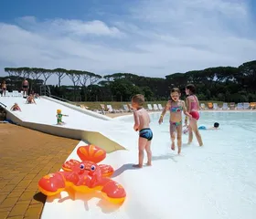 Kinderen spelen op de zachte, veilige bodem van het lagune zwembad op de kindvriendelijke camping Park Albatros in Toscane, Italië.