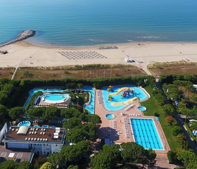 Luchtfoto van Camping Union Lido met een van de zwembadcomplexen direct gelegen aan het brede zandstrand en de Adriatische Zee.