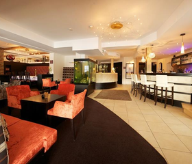 Ruimte met verschillende zithoeken en een bar in een hotel