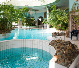 Het subtropische zwemparadijs Aqua Mundo van Center Parcs Port Zélande, met zwembaden omgeven door rotsen en tropische planten.