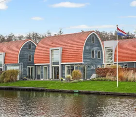 Moderne waterwoningen met opvallende ronde, rode daken direct aan het water gelegen op Villapark de Bloemert.
