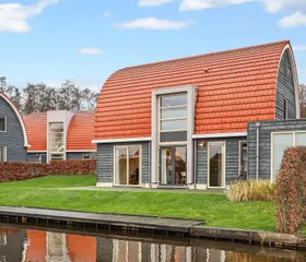 Een vakantiewoning met een terras en tuin direct gelegen aan het water op Villapark de Bloemert in Drenthe.