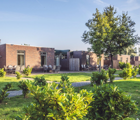 De moderne vakantiehuizen met zonnige terrassen, gelegen in het groene landschap van Recreatiepark De Scherpenhof.