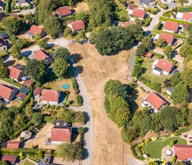 Luchtfoto van de verspreid liggende vakantiehuizen op De Tolplas, met rode daken en veel groen tussen de woningen.
