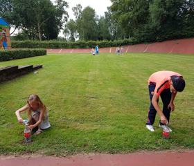 Twee kinderen spelen op de grasmat in het midden van de oude wielerbaan op het vakantiepark in Wageningen.