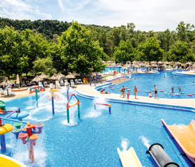 Kinderbad met kleurrijke sproeiers en kleine glijbanen in het Aqualand waterpark, ideaal voor peuters en jonge kinderen.