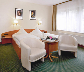 Comfortabele en lichte tweepersoonskamer in Hotel Burgfrieden met zachte bedden, zithoek en een groot raam, ideaal voor een gezinsvakantie in de Moezel.