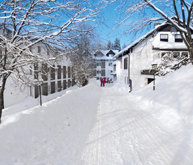 Een diep besneeuwd pad bij Hotel Winterberg Resort, ideaal voor een winterwandeling of slee-avontuur.