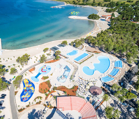 Luchtfoto van Zaton Holiday Resort met zowel het grote zwembadcomplex als het kindvriendelijke zandstrand aan de Adriatische kust in Kroatië.