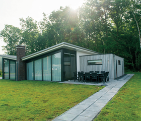 Een moderne design bungalow met grote glazen pui, gelegen in het bosrijke gebied van de Utrechtse Heuvelrug op Landal Amerongse Berg.