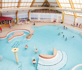 Overzicht van het ruime, overdekte zwemparadijs van Landal Beach Resort Ooghdyne met recreatiebad en spelende gasten.