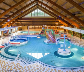 Overzicht van het grote overdekte zwemparadijs van Landal Coldenhove met een glijbaan, kinderbad en bubbelbad.