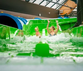 moeder en dochten glijden van de groene duo slide in het zwemparadijs van landal de lommerbergen