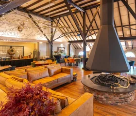 Het sfeervolle interieur van het restaurant op Landal De Wedderplassen, met een grote open haard in het midden.