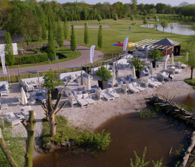 Overzicht van boven van de grote, avontuurlijke waterspeeltuin met rotsen, zand en waterpartijen op vakantiepark Landal Klein Oisterwijk.