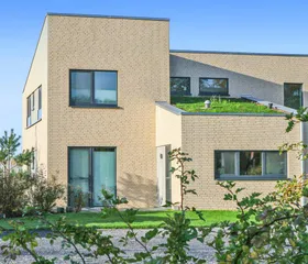 Duurzame en modern ontworpen vakantiewoning op Landal Marissa met een groen dak en strakke architectuur, omgeven door groen.