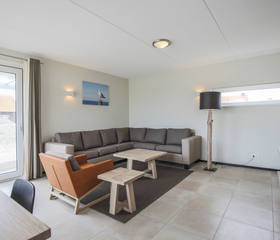 Lichte en moderne woonkamer met een grote hoekbank in een vakantiehuis op Landal Sneekermeer.