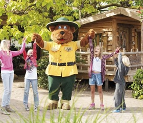 Kinderen dansen en zingen vrolijk samen met de mascotte Bollo de Beer bij de Kids Club van Landal Stroombroek.